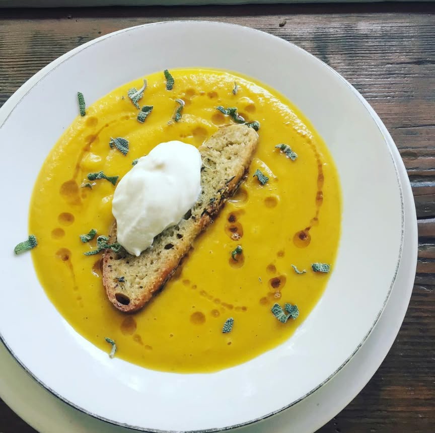Butternut soup with toasted bread, whipped cream and sage